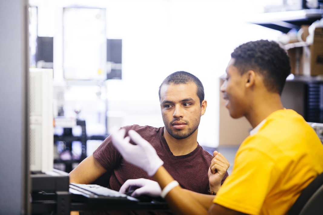 two male students working on a computer together